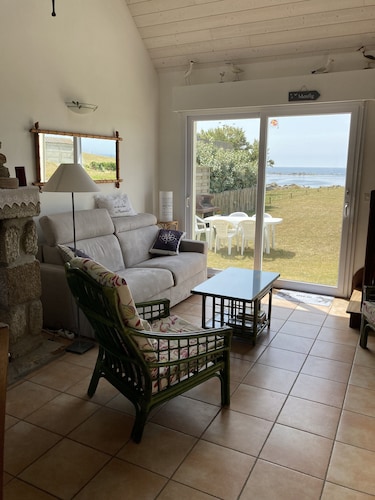 House facing the sea, feet in the water.           