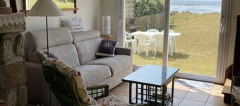 House facing the sea, feet in the water.           