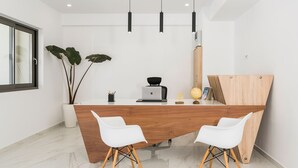 Una cocina moderna con una isla de madera, sillas blancas y lámparas colgantes.