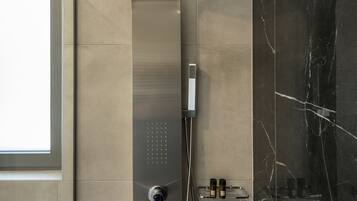 Een moderne douche met bedieningspaneel, douchekop en handdouche.