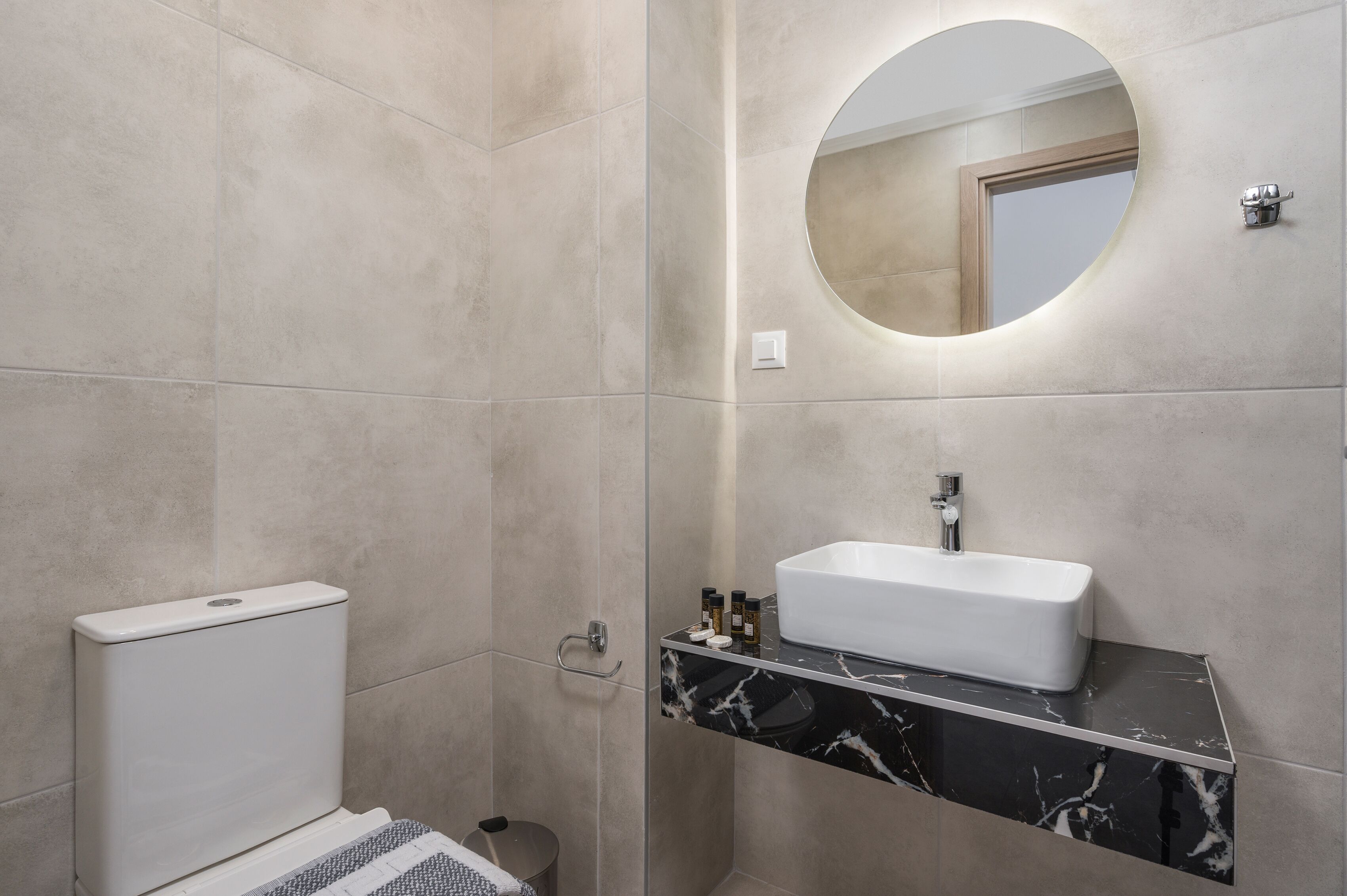 Une salle de bain moderne avec des toilettes, un lavabo et un miroir.
