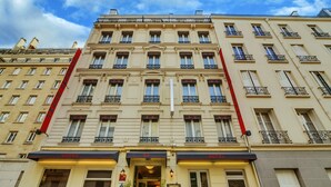 Un hôtel à plusieurs étages, de style architectural européen classique, caractérisé par des fenêtres et des balcons disposés de manière symétrique.
