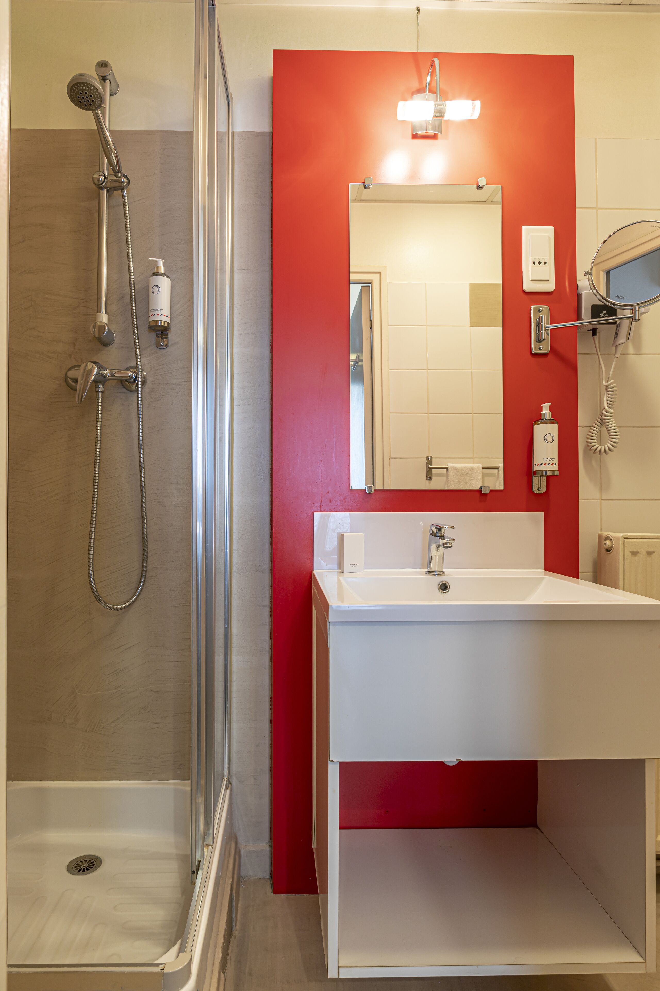 A bathroom with a shower, a sink, and a mirror.