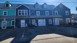 A two-story building with a blue exterior, a bar on the ground floor, and a parking lot in front. - Harrison Hotel Unit F
Pet Friendly 
Ground Level (Murrells Inlet)