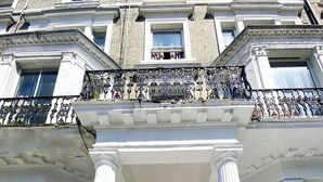 A building with a grand entrance featuring a set of stairs leading to a door marked with the number 120. - Holland Rd Studios Close to Olympia London (London)