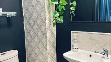 Une salle de bain avec des toilettes, un lavabo et une poubelle.