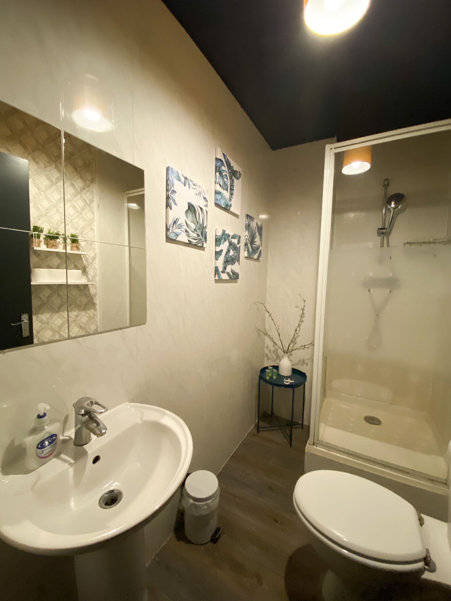 Une salle de bain moderne avec un grand miroir, deux lavabos, des toilettes et une douche.