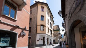 A narrow street with buildings featuring traditional architecture, including balconies and large windows. - Andreola 1 - Two Bedroom Apartment, Sleeps 6 (Bormio)
