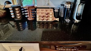 Un plan de travail de cuisine avec une machine à café, une bouilloire et un moulin à café.