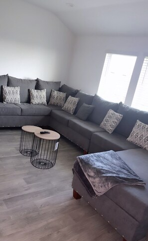 Relax in this stylish living room with a comfortable sofa, coffee table, and large window.