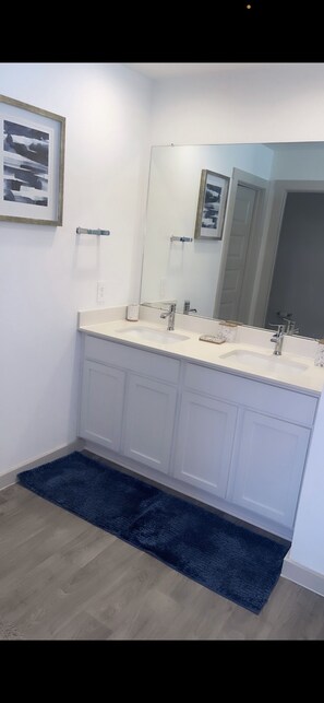 Bathroom features a double vanity and large mirror.
