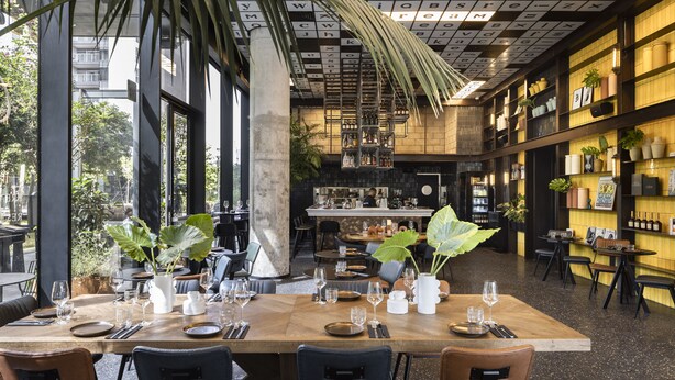 Een restaurant met een grote eettafel, gedekt voor een maaltijd, omringd door stoelen.