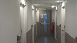 Een gang met aan beide kanten deuren, een brandblusser en een bordje met een rookverbod.