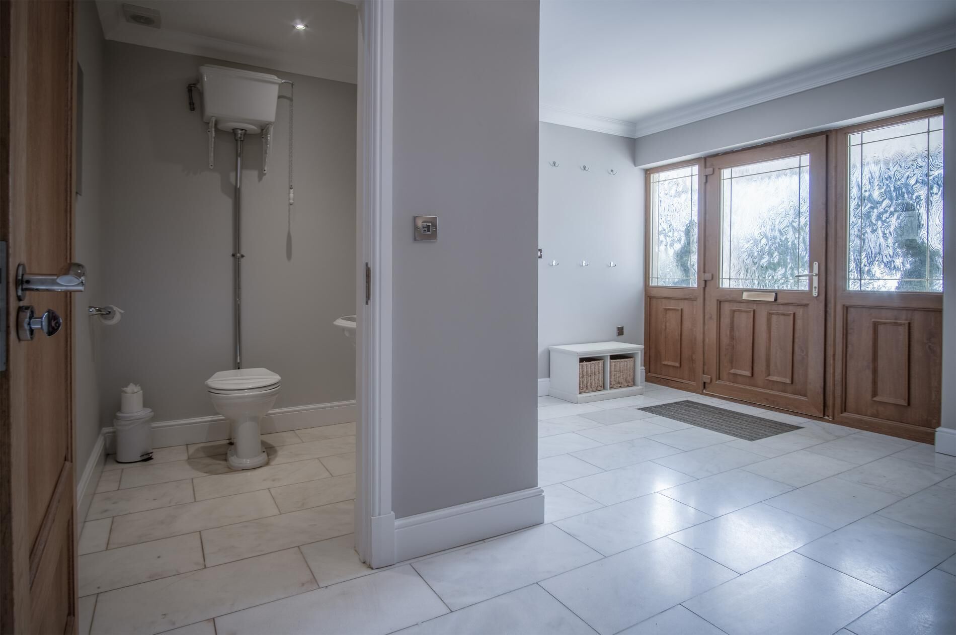 A spacious bathroom with a toilet, shower, and a large window with frosted glass.