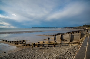 Una spiaggia costiera con muretti di legno e ciottoli.