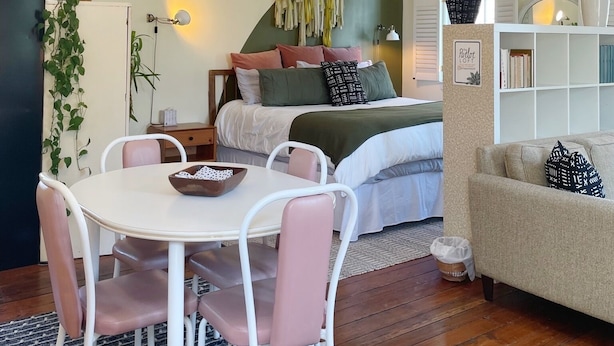 Un dormitorio acogedor con cama, mesita de noche y una lámpara colgante.