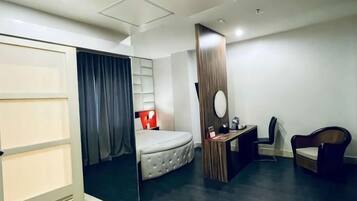 Ein modernes Hotelzimmer mit Bett, Schreibtisch, Stuhl und Spiegel.