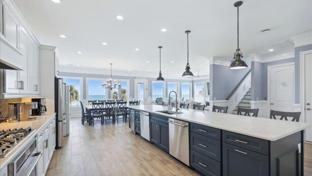 A spacious kitchen with a large island, modern appliances, and a view of the ocean.