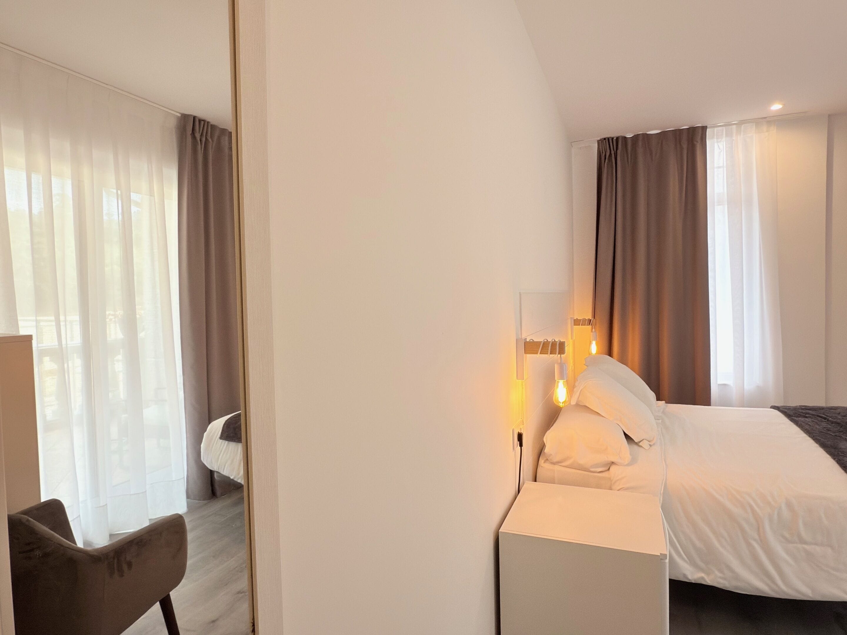 Una habitación de hotel con cama, una silla y un escritorio.