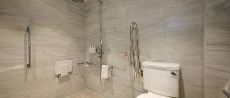 A modern bathroom with a shower, toilet, and hand dryer.