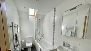 Une salle de bain moderne équipée de toilettes, d’une douche, d’une baignoire et d’un lavabo.