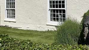 Un bâtiment blanc doté de nombreuses fenêtres et d’une cheminée.