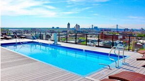 A rooftop pool with a city view, including a bridge and buildings. - XL Studio - Modern Studio with Rooftop Pool (Philadelphia)