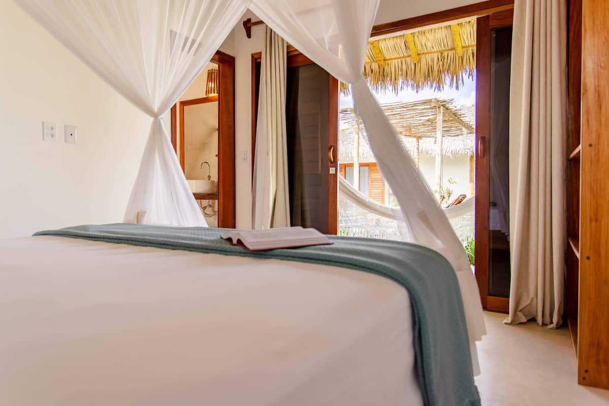 Un dormitorio con cama, un libro y vistas al exterior.