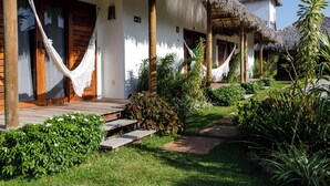 A resort with thatched-roof cottages, a wooden porch, and a well-maintained garden. - Vilarejo Preá (Cruz)