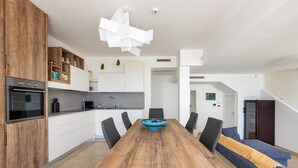 Una cocina moderna con una mesa de comedor de madera, sillas negras y un cuenco azul.