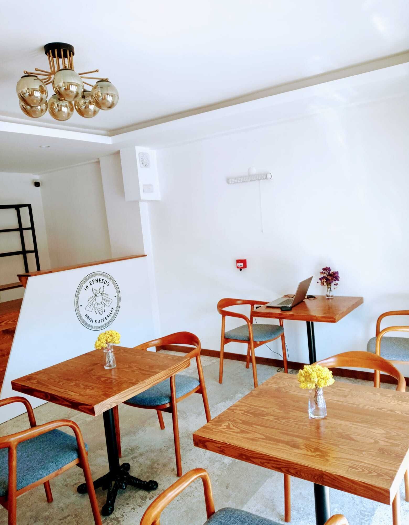 Une chambre d’hôtel moderne, dotée de meubles en bois, d’un lustre et d’un logo sur le mur.