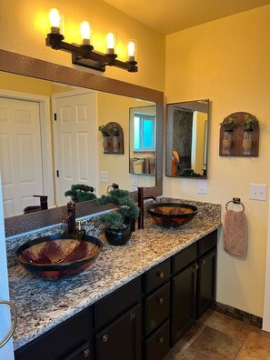 A bathroom with a large vanity, a vessel sink, a mirror, a towel rack, and a wall-mounted light fixture. - Family Oasis - Pool • Spa • Boat Parking • Sleeps 10 (Lake Havasu City)