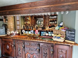 A bar area with wooden decor, a variety of bottles, and a chalkboard menu.