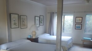 A hotel room with two beds, a sofa, a nightstand with a lamp, and framed pictures on the wall. - A rare combination of central location convenience & private island seclusion  (George Town)