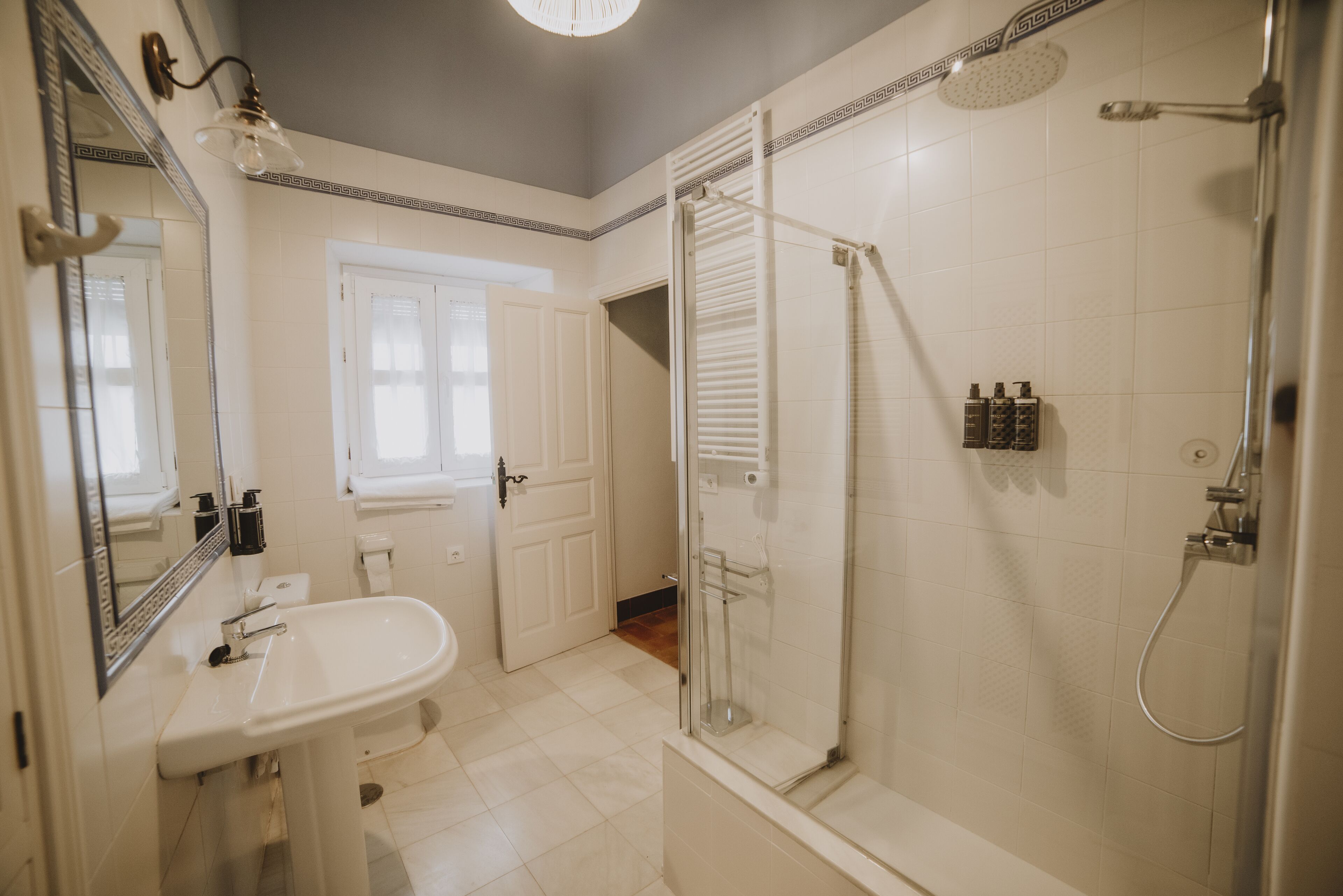 Une salle de bain avec un lavabo, un miroir et une douche.