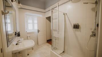 Une salle de bain avec un lavabo, un miroir et une douche.
