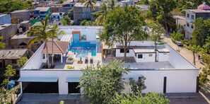 A rooftop pool with a clear blue pool, surrounded by white buildings and palm trees. - Casa Palxocotl with Private Pool and Pickleball Court for large groups. (Bucerías)