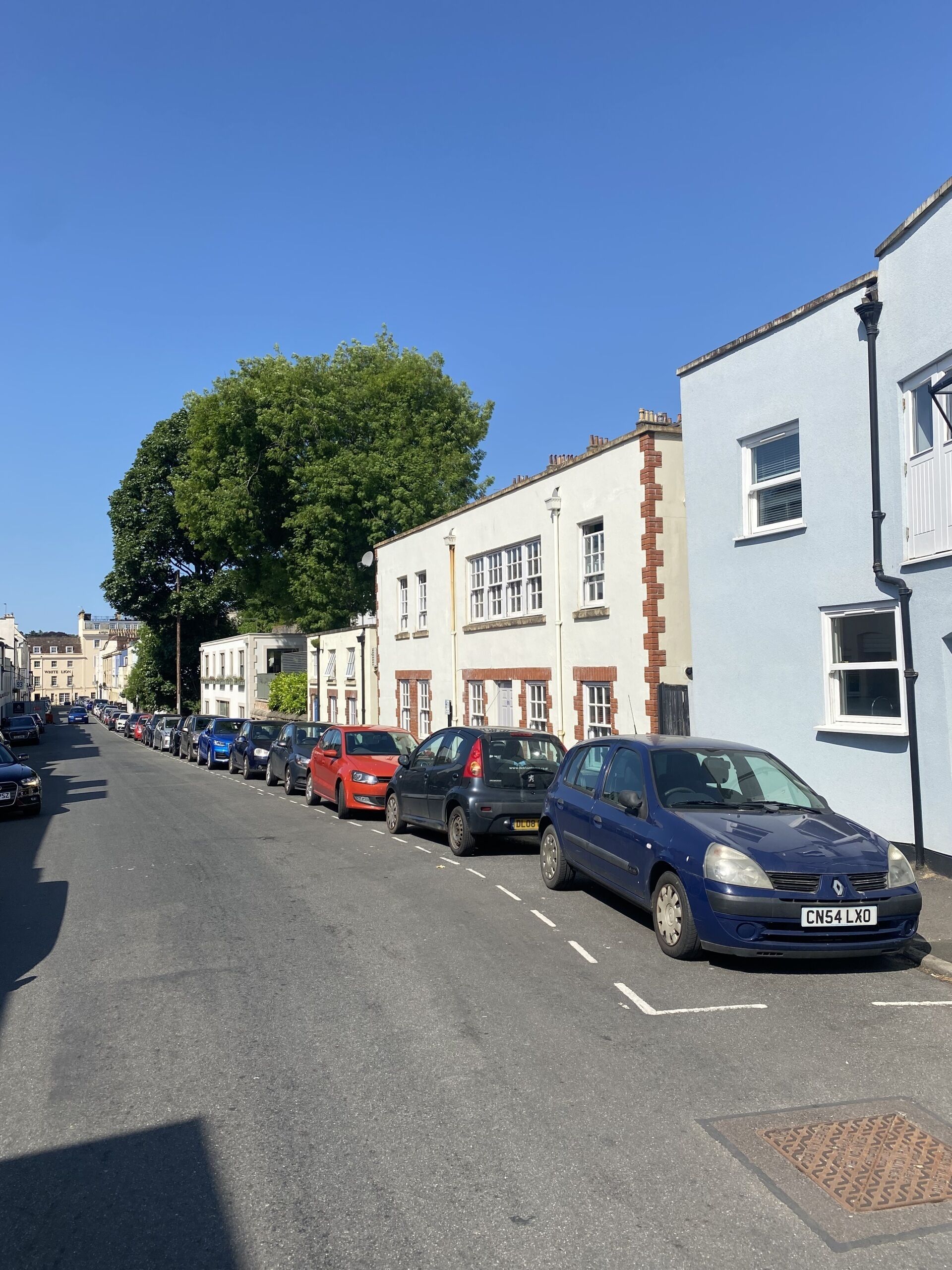 A street lined with parked cars and buildings.