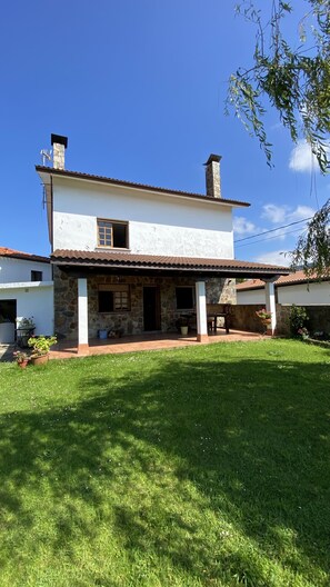 Stunning two-story house with a covered patio and beautifully manicured lawn.
