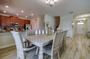 A spacious kitchen with wooden cabinets, a granite countertop, and modern appliances. - Champions Gate Luxury 6 Bedroom Resort Villa With Spa and Games Room on Golf Course community (Davenport)