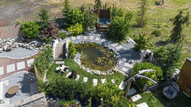 A garden with a pond, seating areas, and a hot tub. - AGRITURISMO SAN GALLO (Bormio)