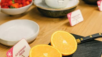Aamiainen tarjoillaan buffetpöydästä, ja siellä on monenlaista syötävää sekä kyltti, jossa kerrotaan, että tarjolla on appelsiinimehua.