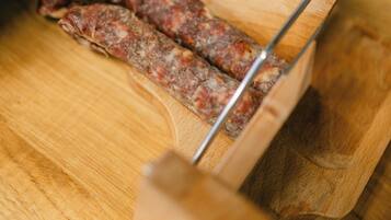A wooden cutting board with a pair of scissors and a piece of meat on it.