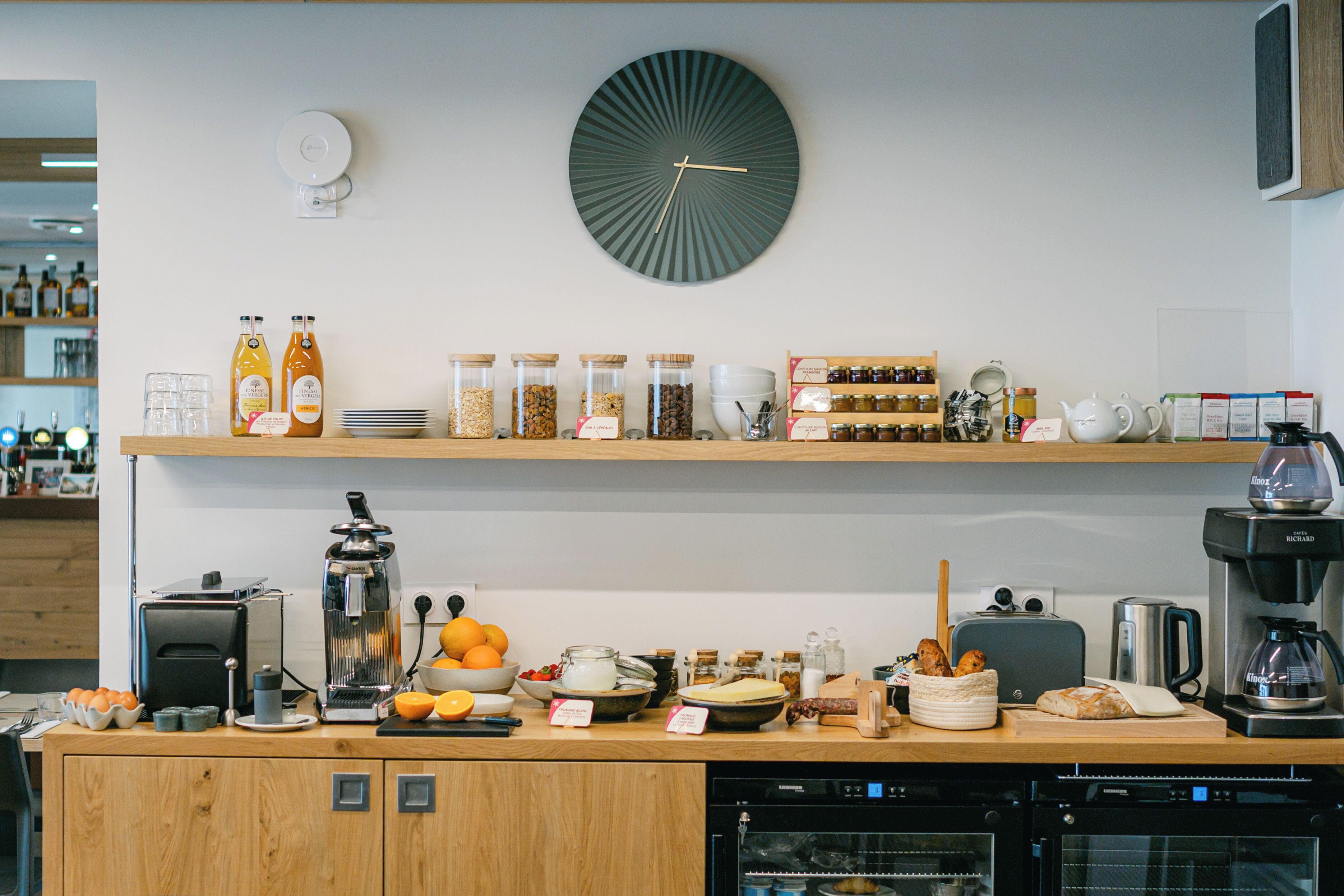 Una cocina con cafetera, tostadora y diversos alimentos sobre la encimera.