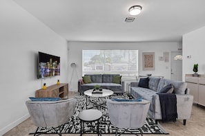 Relax in this stylish living room with a sofa set, coffee table, and armchairs.