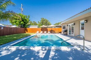 Relax by the pool surrounded by a well-manicured lawn and comfortable seating.