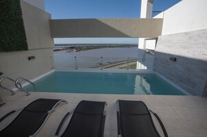 Una piscina al aire libre, sillones reclinables de piscina