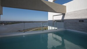 Una piscina interior con vista a un cuerpo de agua y un puente.