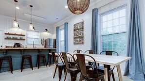 A modern kitchen with a central island, bar stools, and pendant lighting.