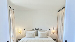 Une chambre à coucher avec un lit, deux lampes de chevet et des rideaux.